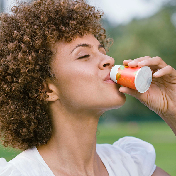 A woman enjoying a drink outdoors