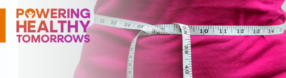 Woman's abdomen being measured with tape measure with text in the top left corner that reads powering healthy tomorrows