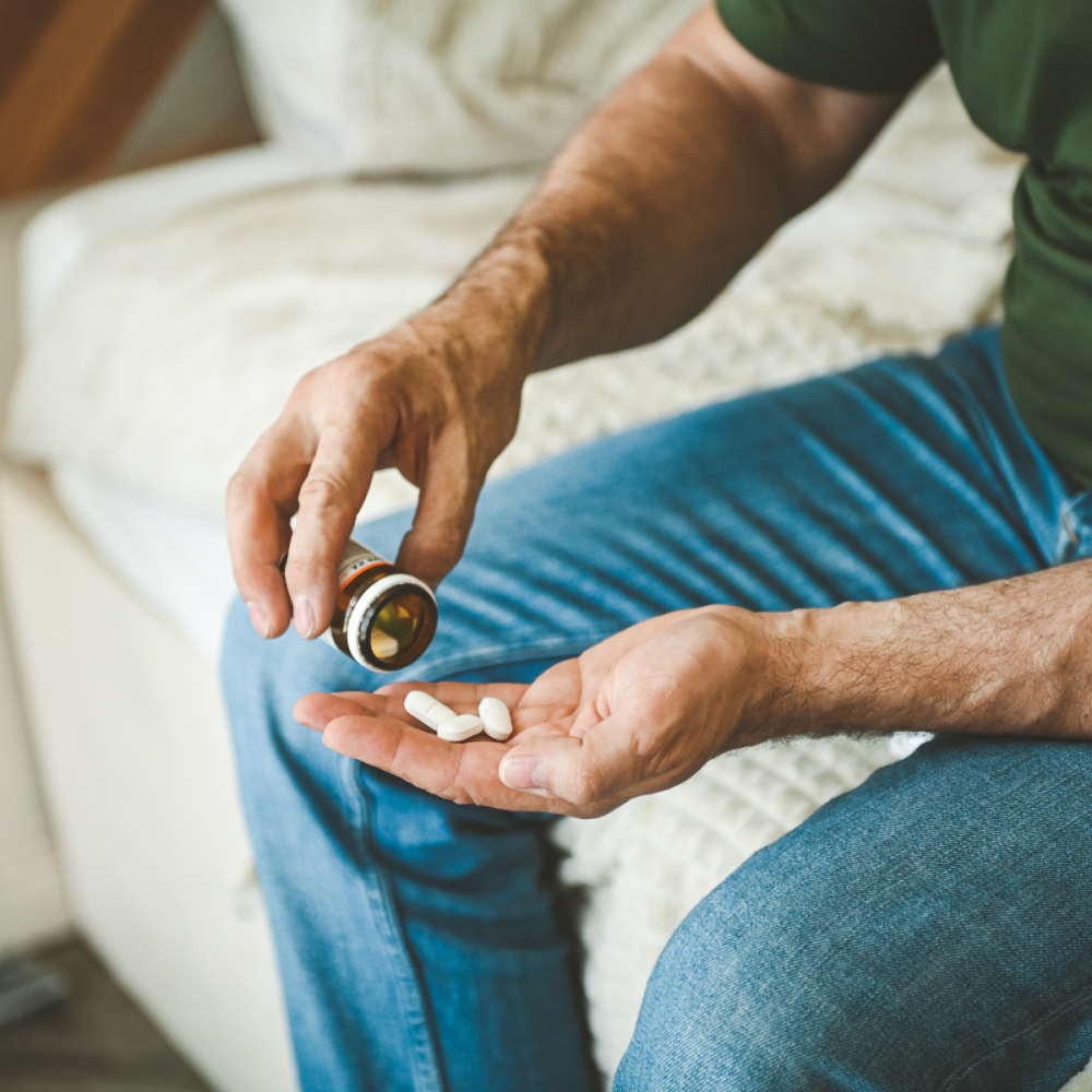 Man pouring pills into his hands from a pill bottle