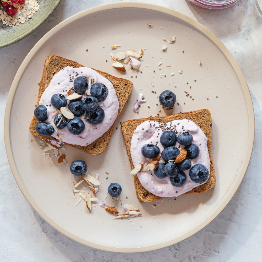 Yogurt and blueberries with almonds placed on top of two pieces of bread