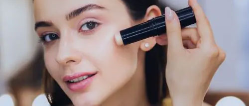 A woman applying make-up from a touchless stick