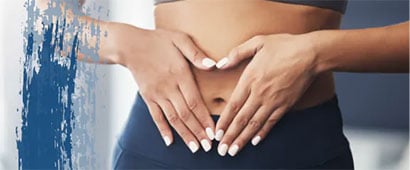 A woman in workout clothes holding her flat stomach