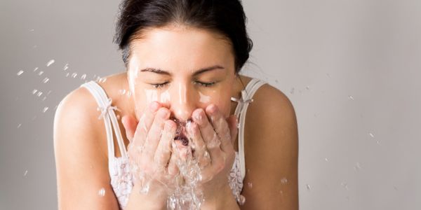 Woman washing her face with water